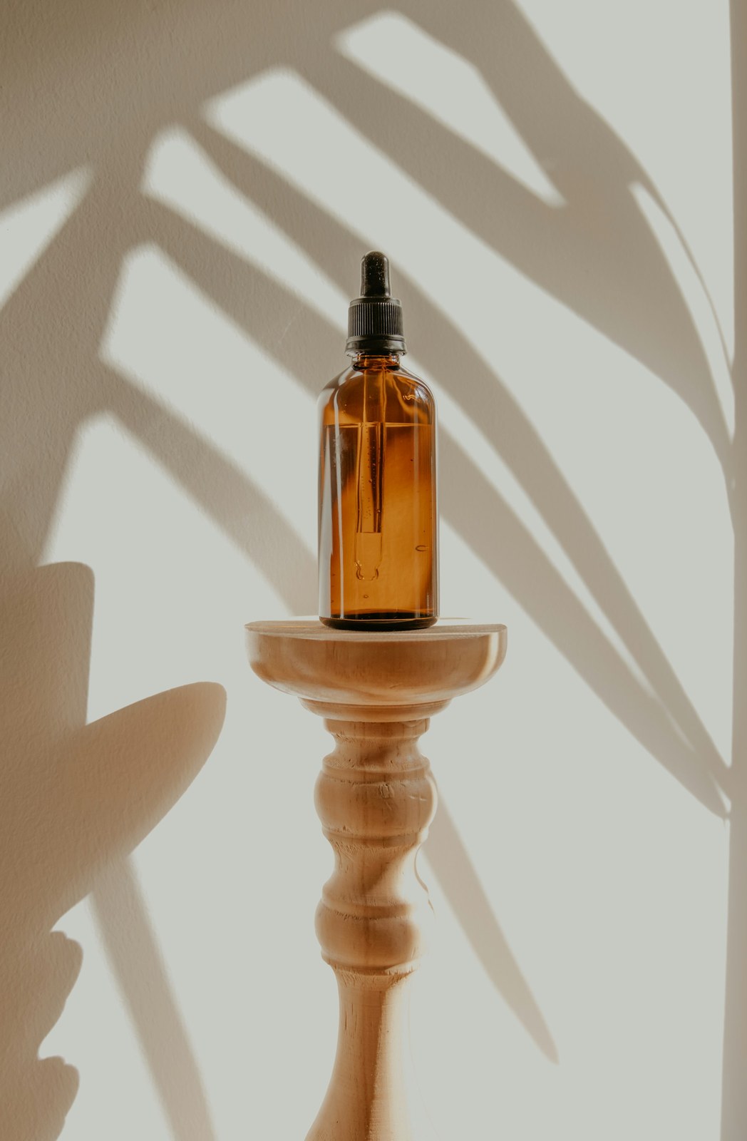 A dropper bottle of hair oil in bright daylight, part of a regular pre-wash oiling routine
